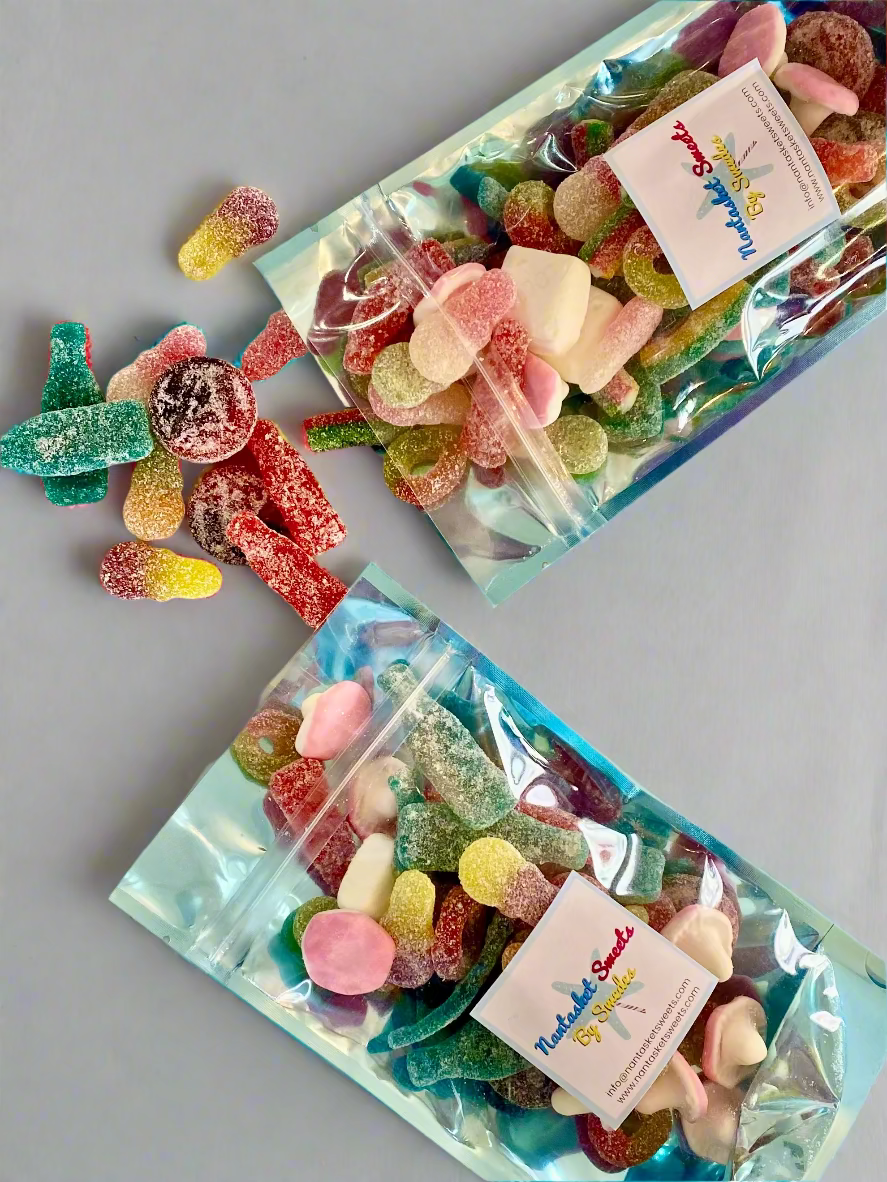 Two packages of colorful gummy candies on a marble surface