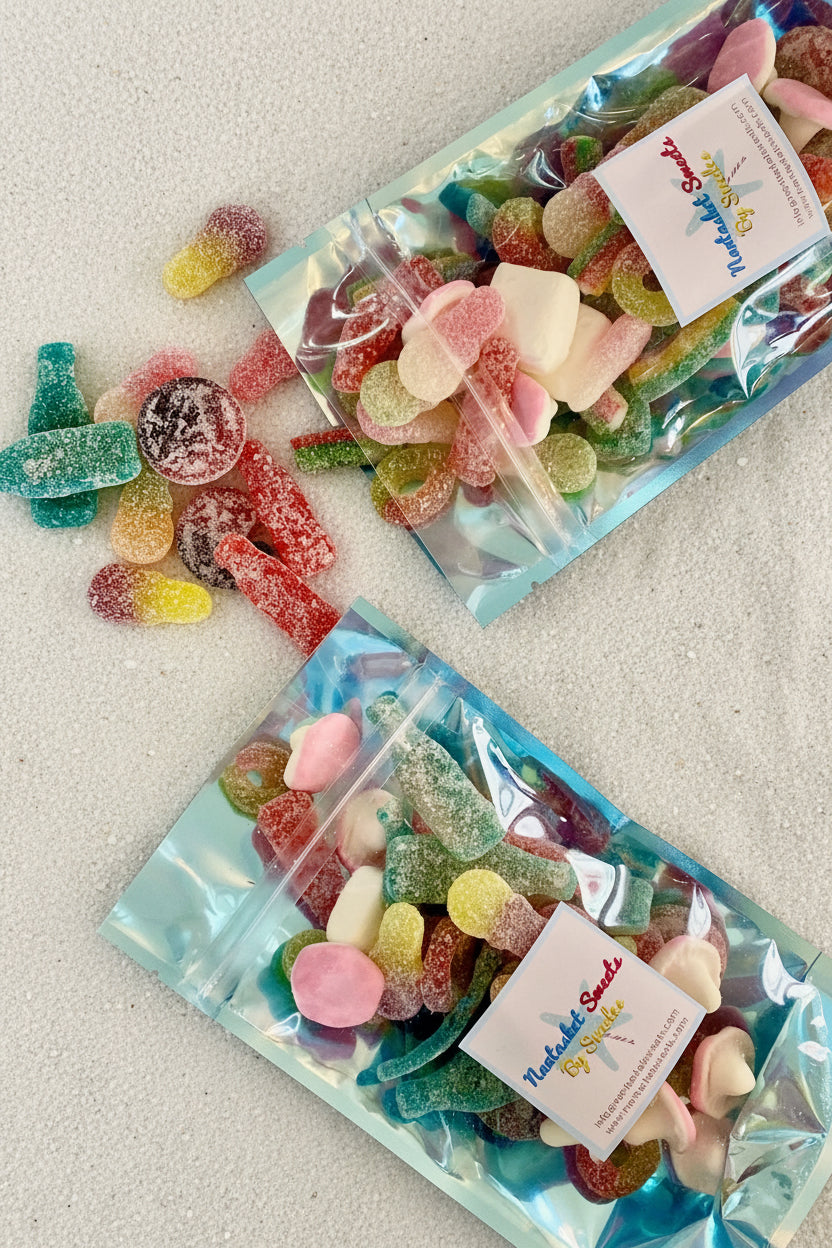 Two packages of colorful gummy candies on a marble surface