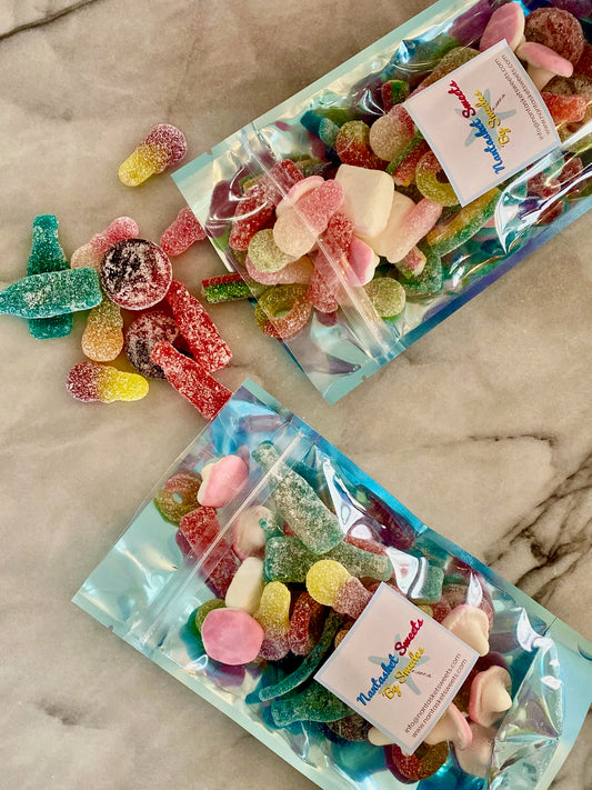 Two packages of colorful gummy candies on a marble surface
