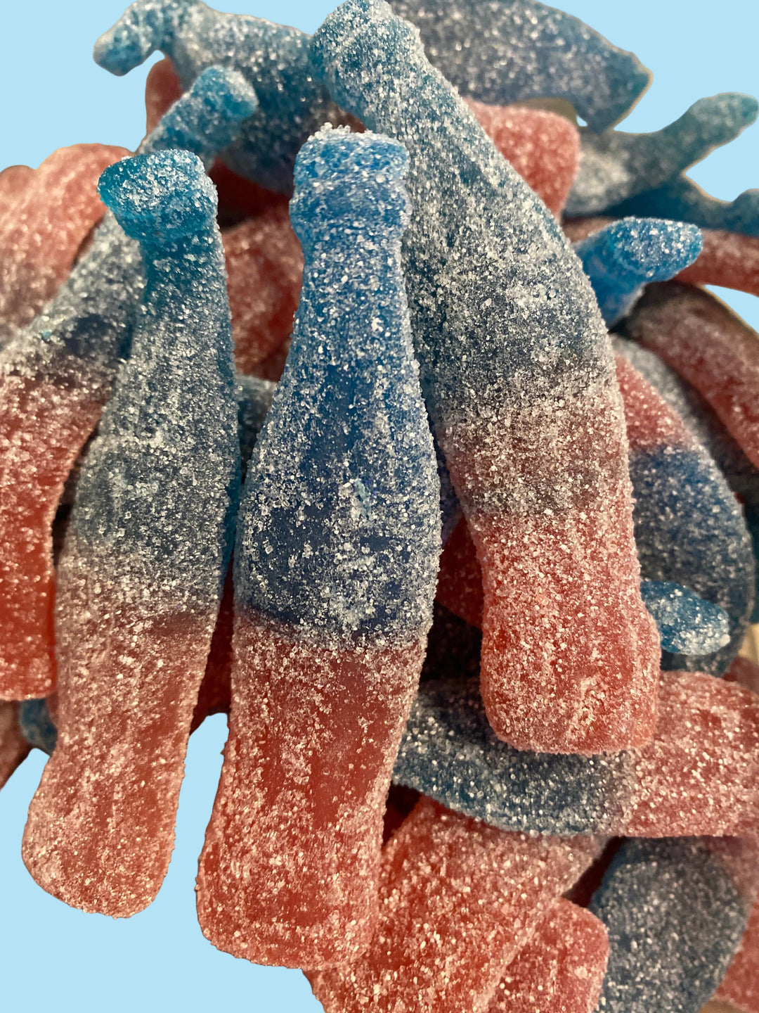 Assorted red, blue, and pink gummy worms on a white background