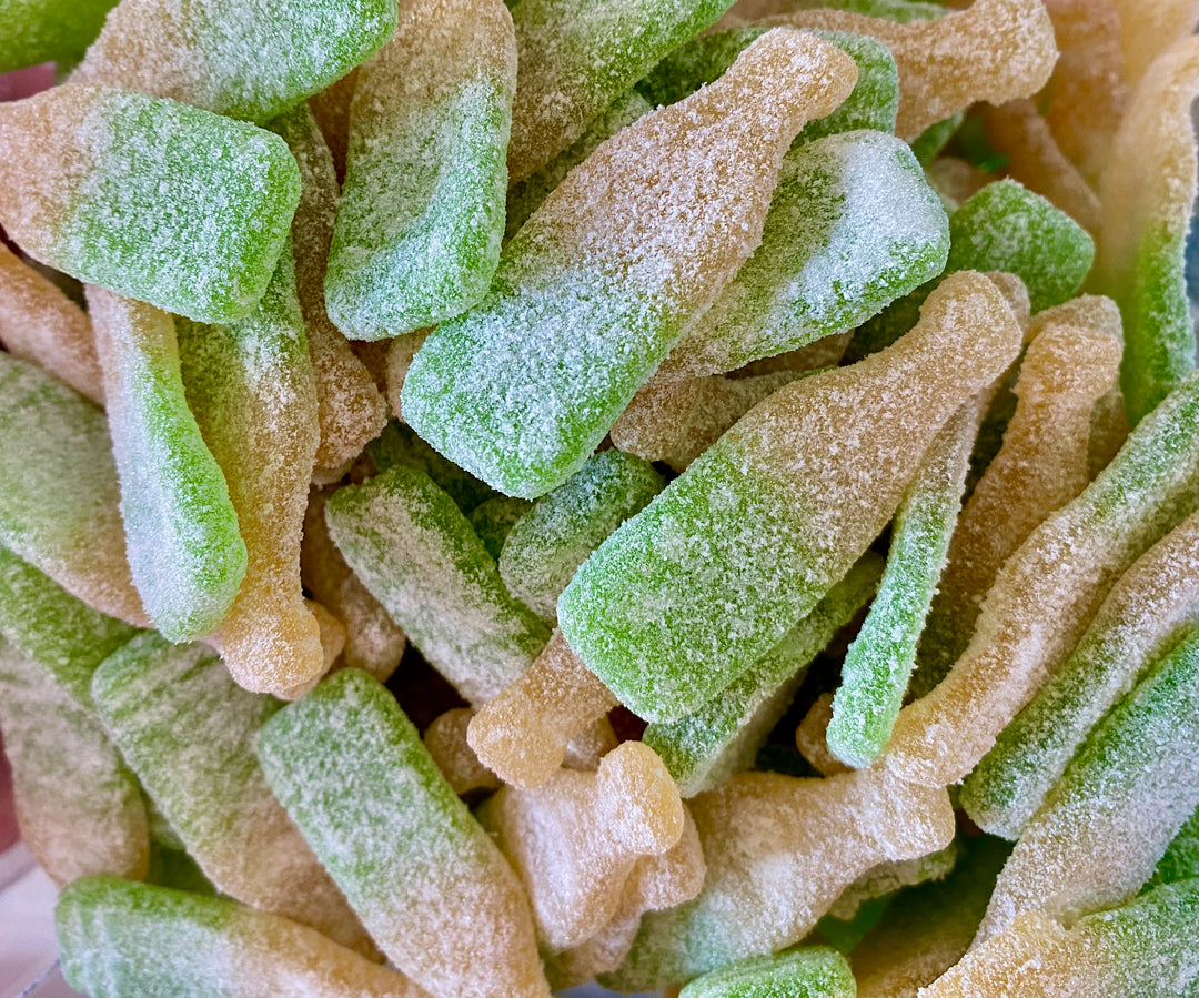 Close-up of green and orange gummy candy pieces.