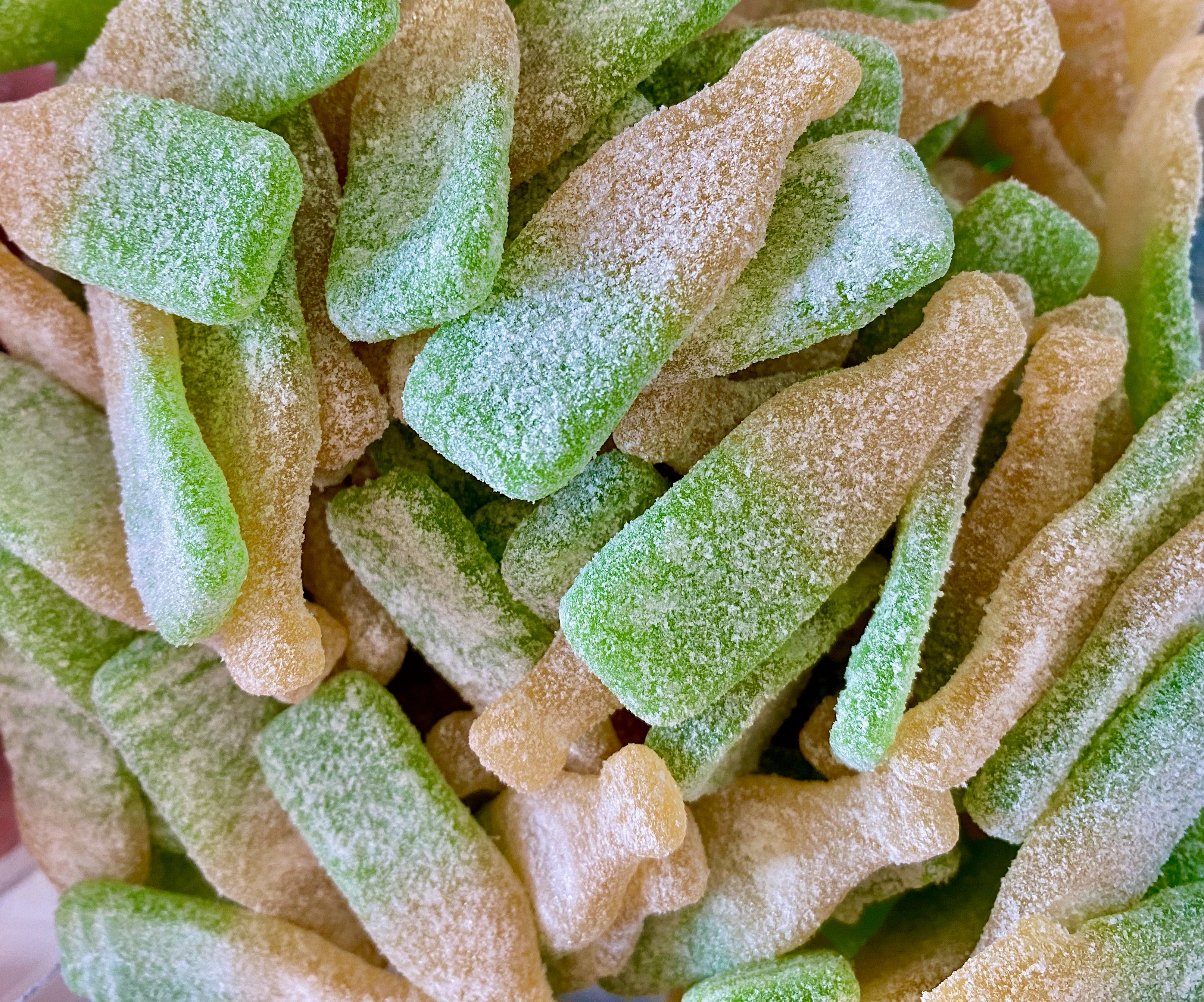 Close-up of green and orange gummy candy pieces.