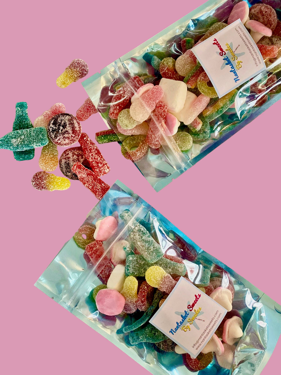 Two packages of colorful gummy candies on a marble surface