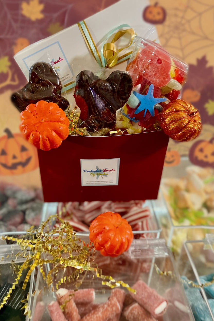 Halloween-themed candy box with gummy worms, pumpkins, and other treats on a Halloween-themed background.