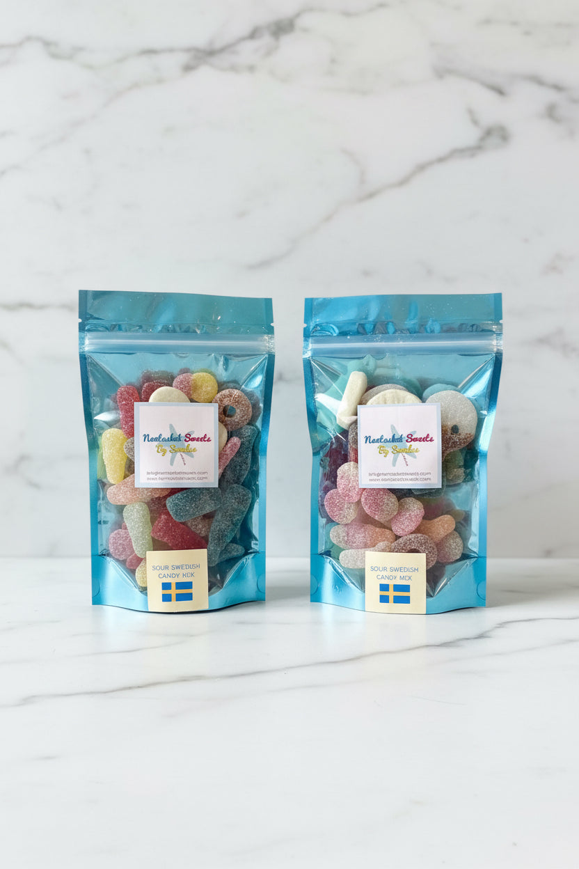 Two packages of Swedish Sweets by Snacks on a reflective surface with a light blue background.
